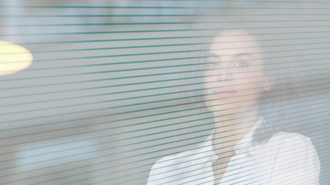 Office woman reflecting behind teal-striped glass, then lifting smartphone to answer client call