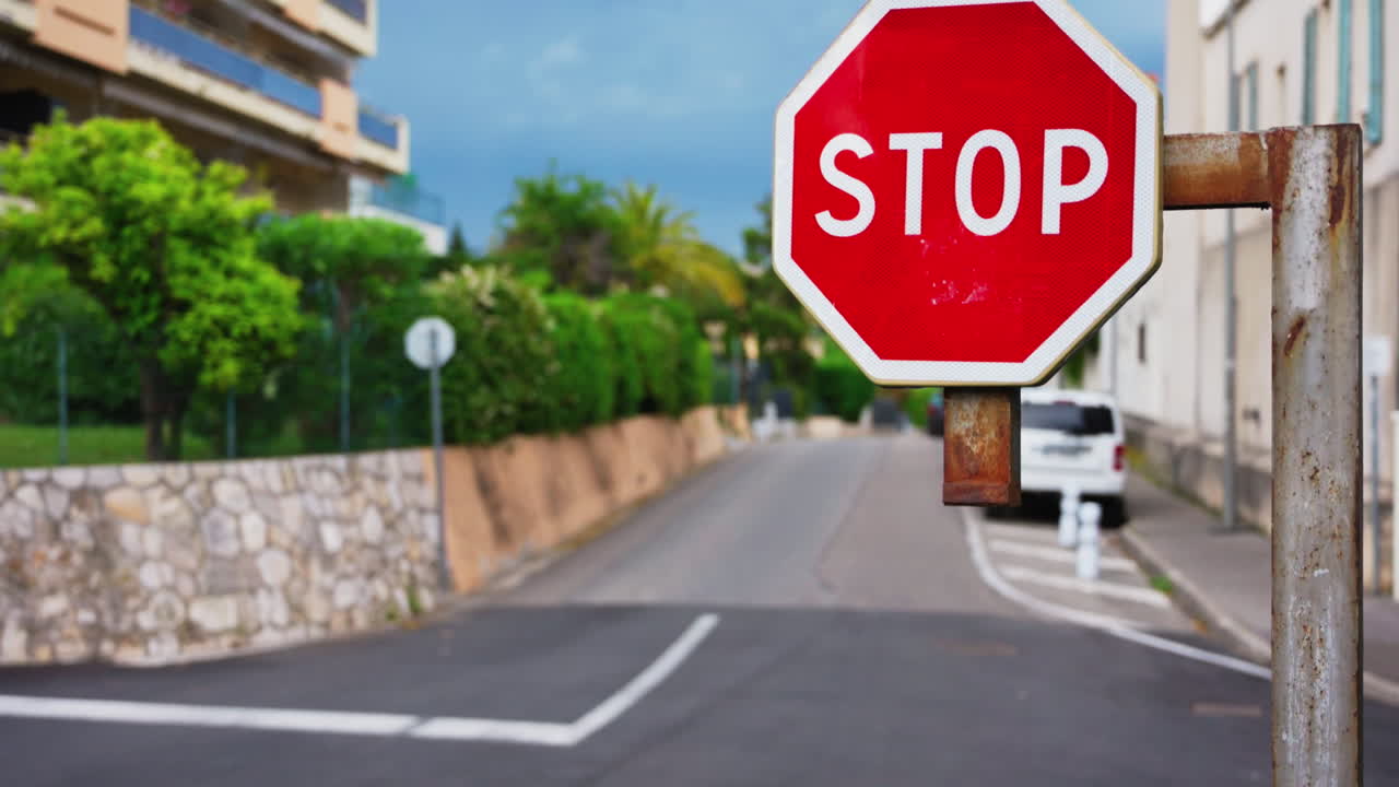 Close up of a stop sign with a blurred background of cars moving on the street