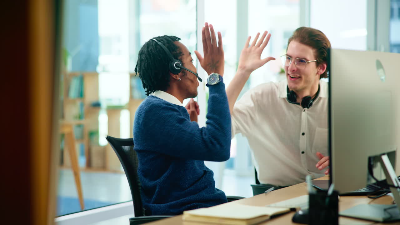 Two colleagues celebrating success in the office with a high five