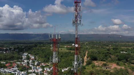 toma aérea con drones, zoom out, de antenas de tecnología móvil, mientras se ve un hermoso pueblo detrás de ellas