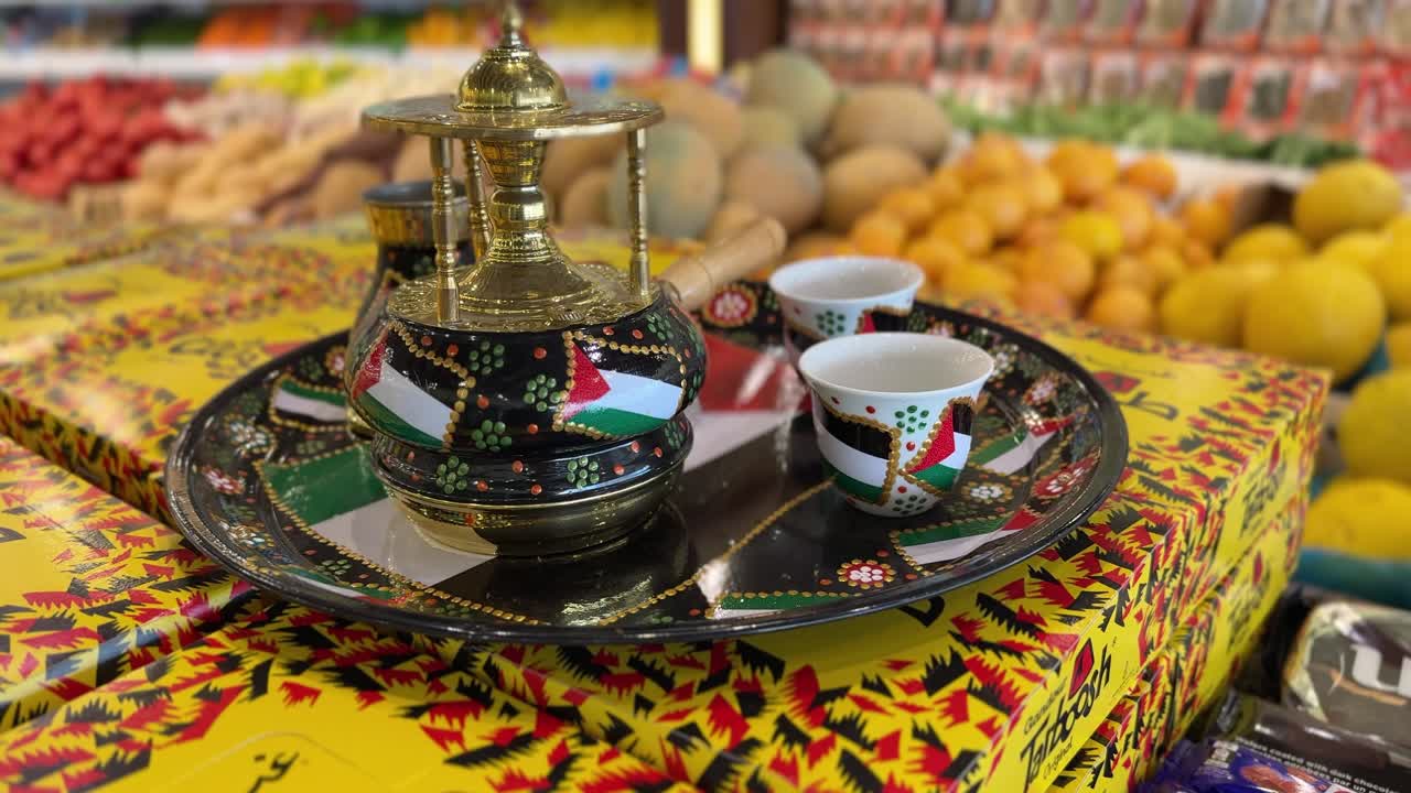 Close-up 4K shot of a traditional Arabic coffee set featuring Palestinian designs, placed on colorful boxes in a vibrant grocery store. Rich cultural and retail elements.