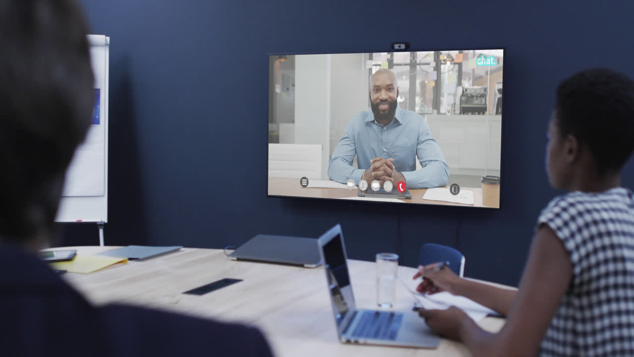 Diverse business people on video call with african american male colleague on screen