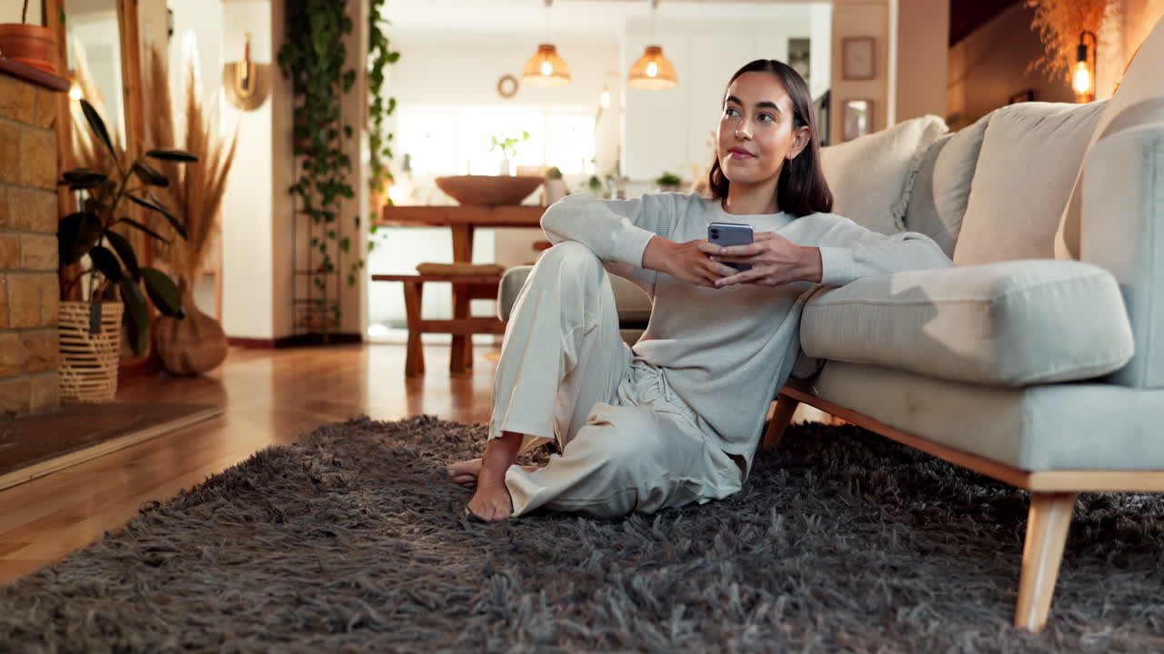 mujer relajándose en el suelo usando el teléfono en la sala de estar