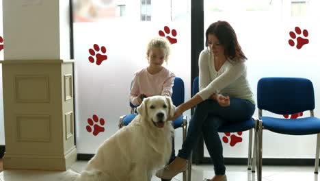 mother and daughter with dog in vet waiting room