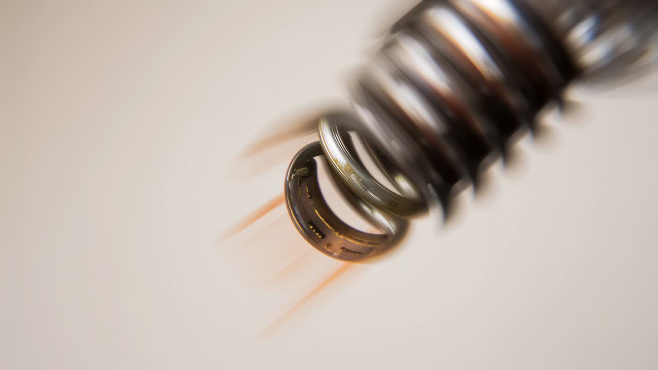 Flexible coil spraying granules and fibers in beige studio as orange glow intensifying near gasket