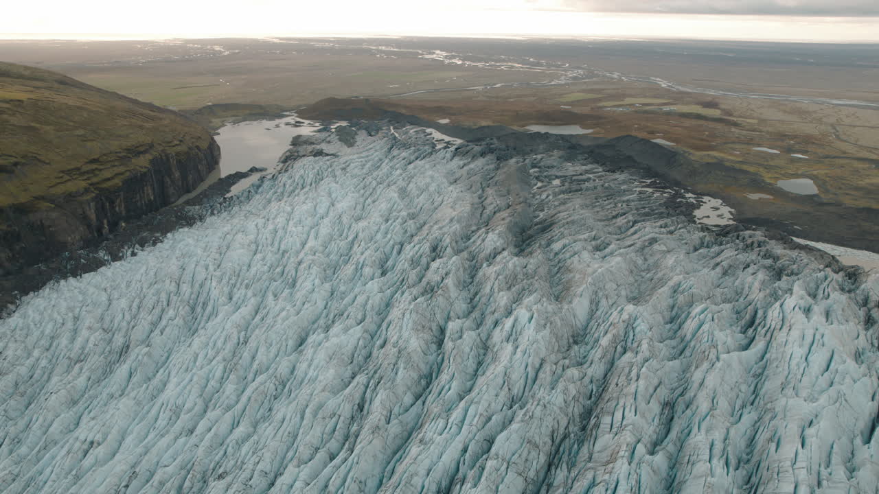 산 아래로 녹색 평원으로 흐르는 아이슬란드의 큰 빙하