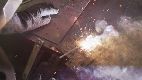 Detail-of-hands-of-Caucasian-male-factory-worker-at-a-factory-standing-in-a-workbench,-welding