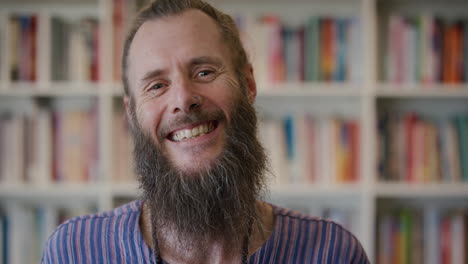 portrait-happy-mature-hippie-man-smiling-entrepreneur-enjoying-successful-lifestyle-bearded-caucasian-male-wearing-nose-ring-in-bookshelf-background