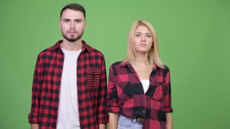 young couple covering eyes together as three wise monkeys concept