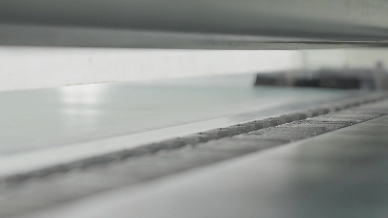 All'interno di una macchina di produzione industriale mentre è in funzione in una fabbrica di pelletteria. Primo piano