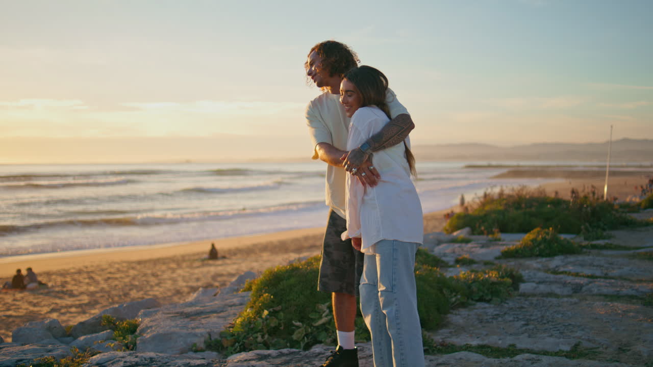 십대 커플은 해가 지는 바다를 즐기고, 젊은 연인들은 안고 만적인 여름 휴가를 보낸다.