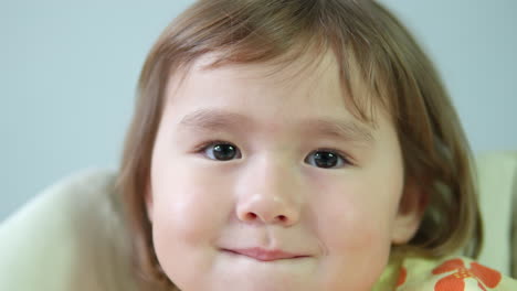 3살의 어린 소녀가 카메라를 쳐다보며 웃고 있는 갈색 눈의 클로즈업 - 눈에서 얼굴로 돌아가는 돌리, 3살의 딸의 행복한 치아 웃음