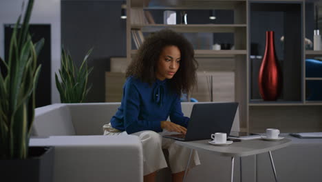 Vielbeschäftigte-Afroamerikanische-Geschäftsfrau-Tippt-Laptop-Tastatur-Und-Trinkt-Kaffee-Bei-Der-Arbeit.