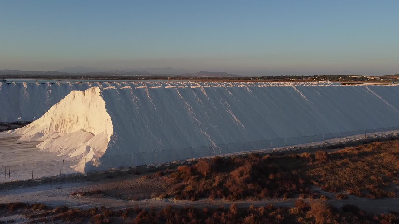 enormes montículos de sal y luego una vista aérea de las bandejas de evaporación o salinas creadas para recolectar sal de la costa mediterránea cerca de santa pola, españa