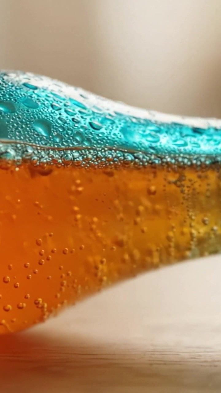 Primo piano di una bottiglia di soda rinfrescante con colori vivaci e bollicine, che mostra i dettagli della carbonazione e della freschezza in un'atmosfera delicata.