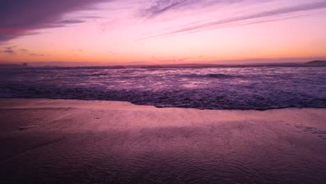 Bei-Sonnenuntergang-Rollen-Rosa-Ozeanwellen-Herein