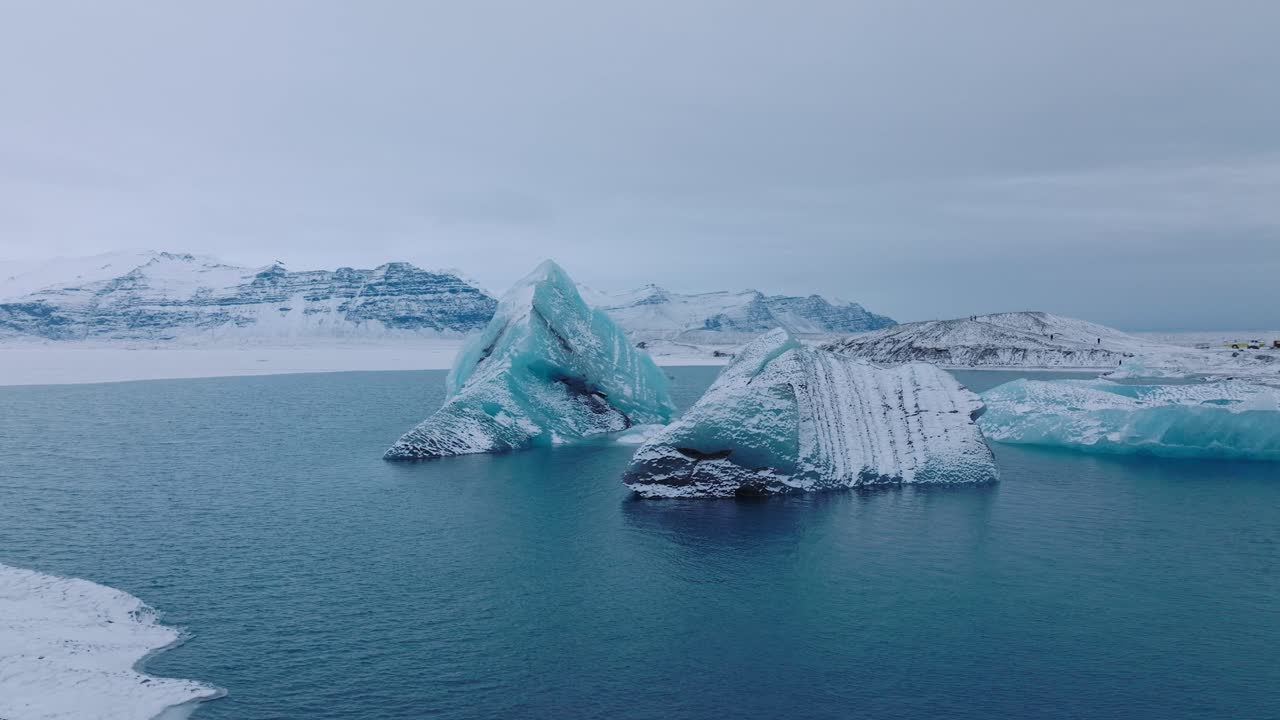 Aerial panoramic landscape view over icebergs in the glacial water of Jokulsarl&oacute;n lake, in Iceland, during winter