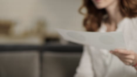 happy woman analysing data on sofa