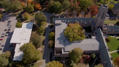 aerial flyover of city park, residential area, and urban park in autumn