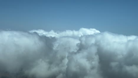 Luftbild-4K-Video-Einer-Wolkenlandschaft-Im-POV,-Bei-Dem-Man-In-Einer-Linkskurve-über-Flauschige-Wolken-An-Einem-Tiefblauen-Himmel-Fliegt