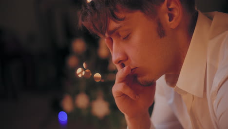 pensive man with hand on chin at home during christmas