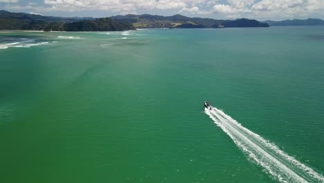 drone volando alrededor de carreras de barcos de pesca a través del agua del océano