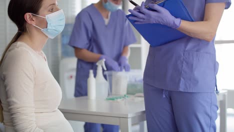 tilt up video of pregnant woman in mask before vaccination