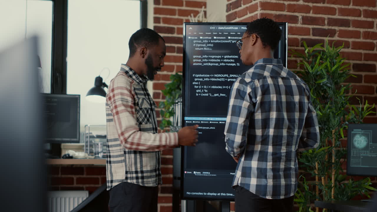 Team of software programmers leaving after analyzing source code on wall screen tv