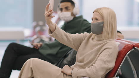 woman having video call in departure lounge