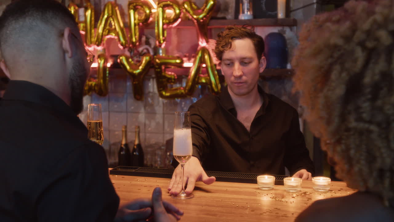 Bartender pours champagne for customers at a New Year's Eve party