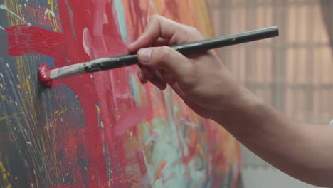 artist hand holding paint brush and painting