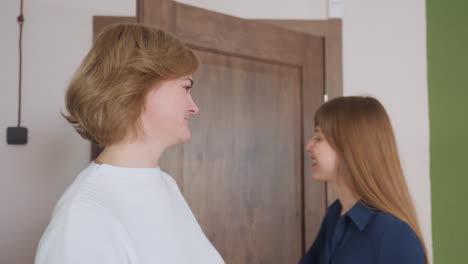 Mental health therapist stands at doorway with open wooden door, preparing to welcome client into therapy space, hair down, warm lighting enhances professional yet friendly environment