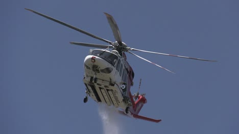 firefighting helicopter drops water on fire