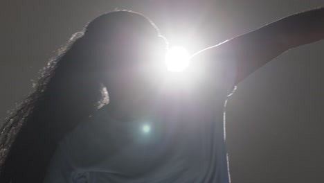 Backlit-Head-And-Shoulders-Studio-Portrait-Shot-Of-Young-Woman-Dancing-In-Spotlight-4