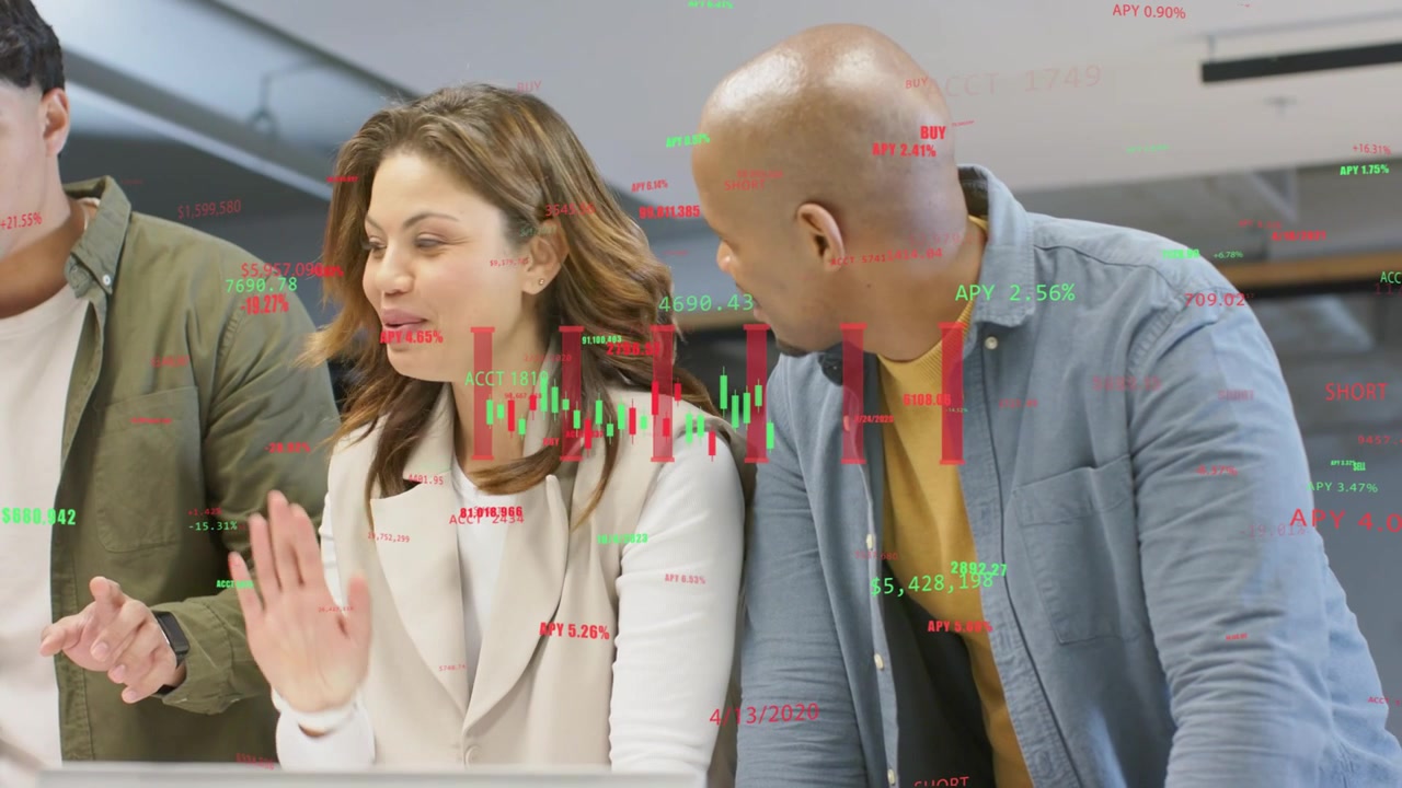 Left coworker pointing at laptop, starting trading charts overlaying screen, team analyzing data