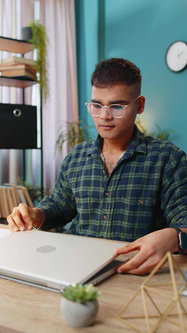Man sitting at table closing laptop pc after finishing online distant work at home office room