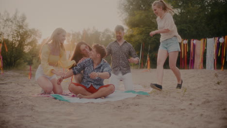 Cheerful-friends-running-towards-man-sitting-on-sarong