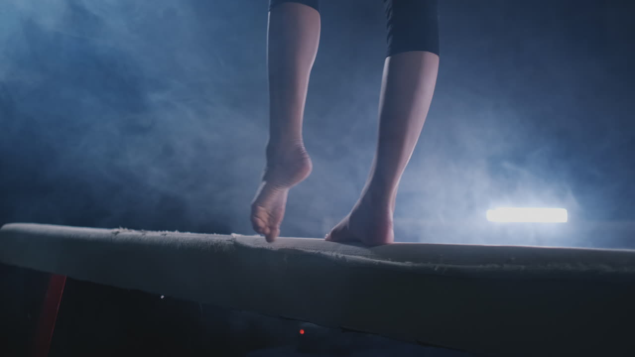 gimnasta practicando en una viga de equilibrio en el gimnasio.