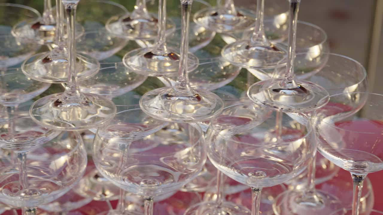 Stacked wine glasses on red table. Banquet preparation setup