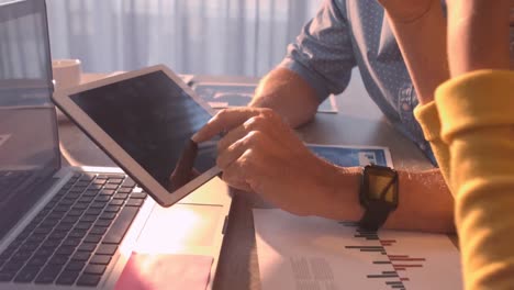 businesspeople discussing over digital tablet while having coffee