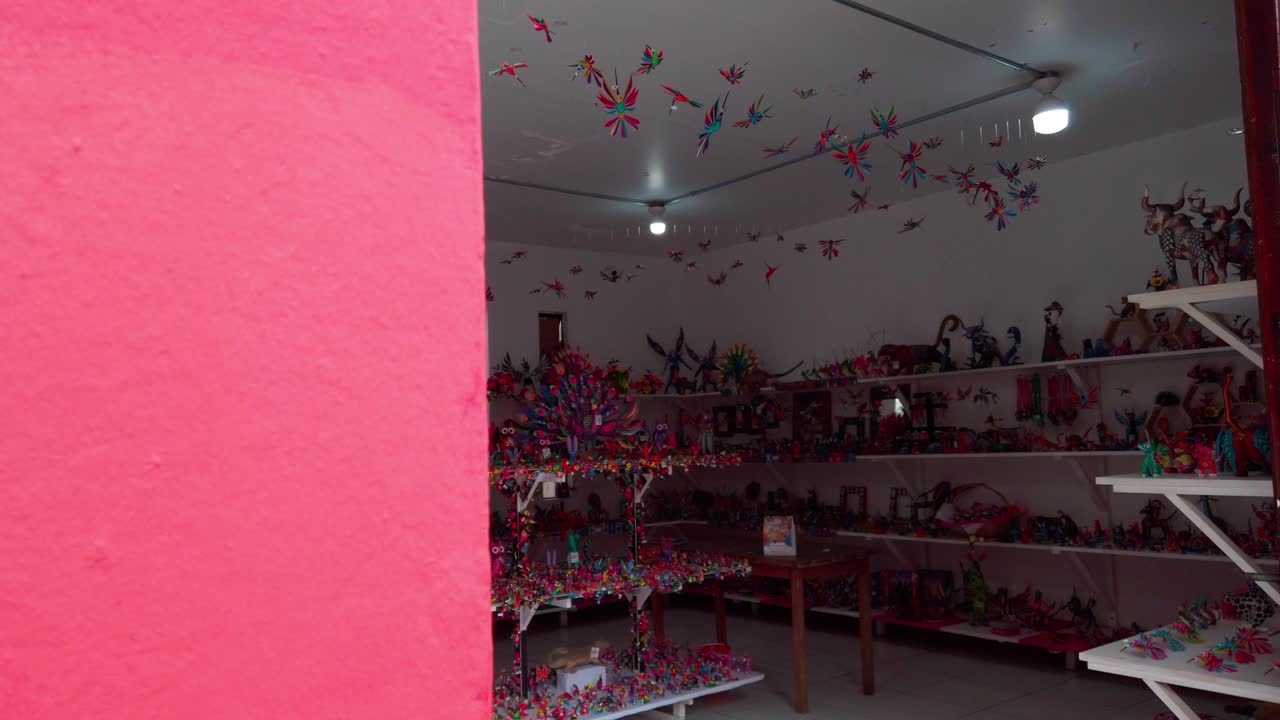 Zoom in shot entering a colorful artisan crafts store filled with handmade figures and decor