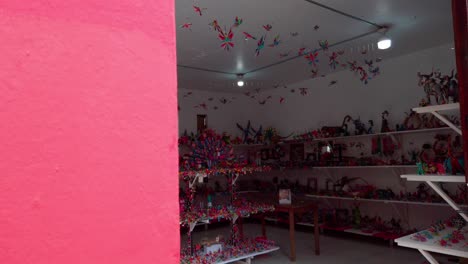 zoom in shot entering a colorful artisan crafts store filled with handmade figures and decor