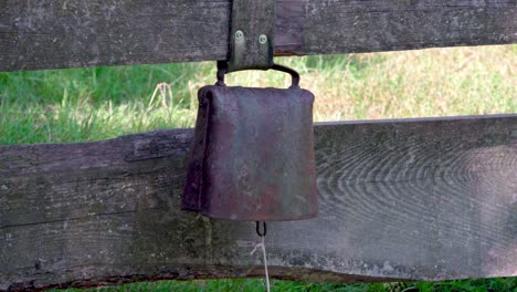 a cowbell used as a warning bell and attached to a wooden fence