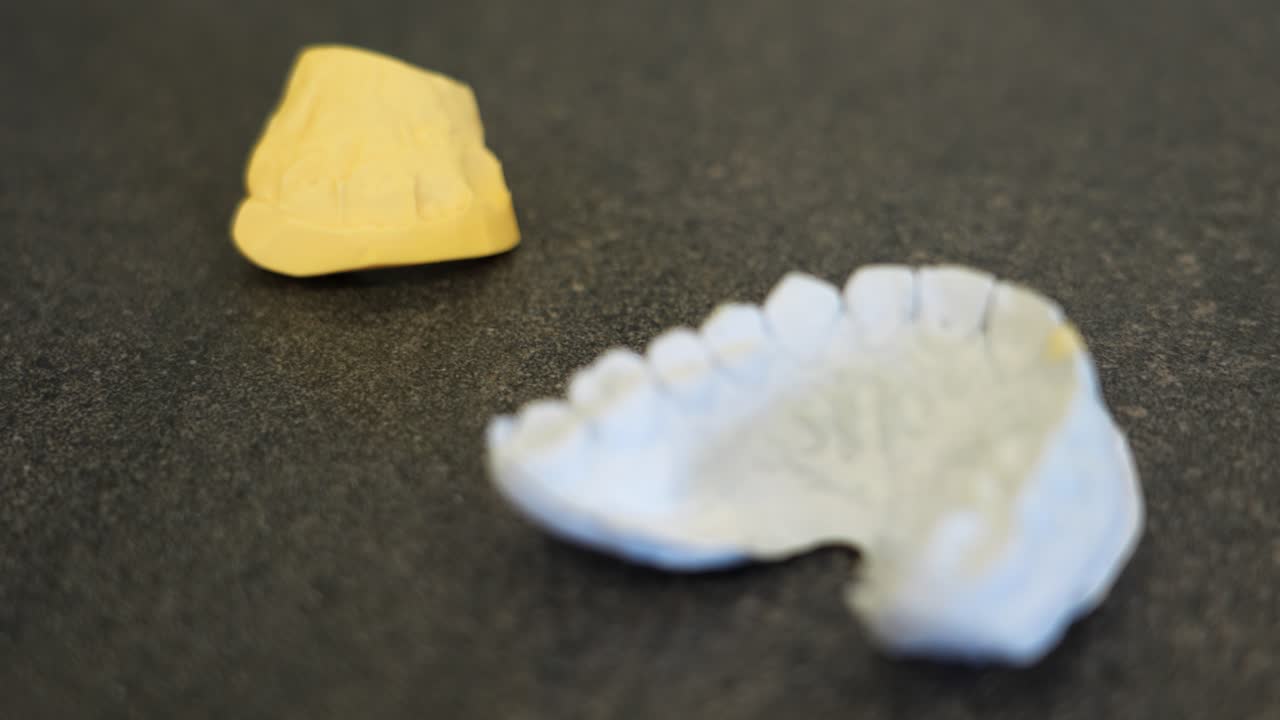 Dental mold with wax impression on a gray surface