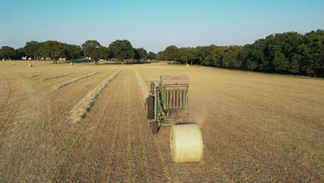 Dolly-shot-of-round-baler-drop-releasing-round-hay-bale