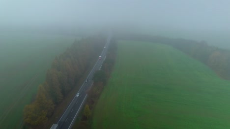 cars and trucks driving on the road through nature