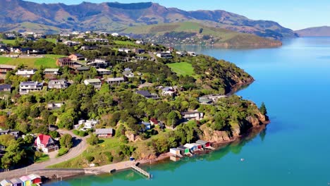cropped aerial footage showcasing coastal homes, lush greenery, and expansive blue waters under clear skies.