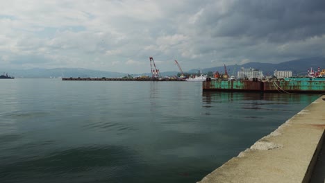 calm waters of port of hakodate from shoreline on overcast day