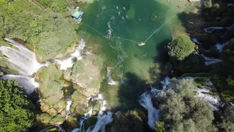 vista desde arriba de la hipnotizante cascada de kravica con agua de color esmeralda, tiro hacia arriba