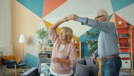 una pareja feliz bailando en casa.